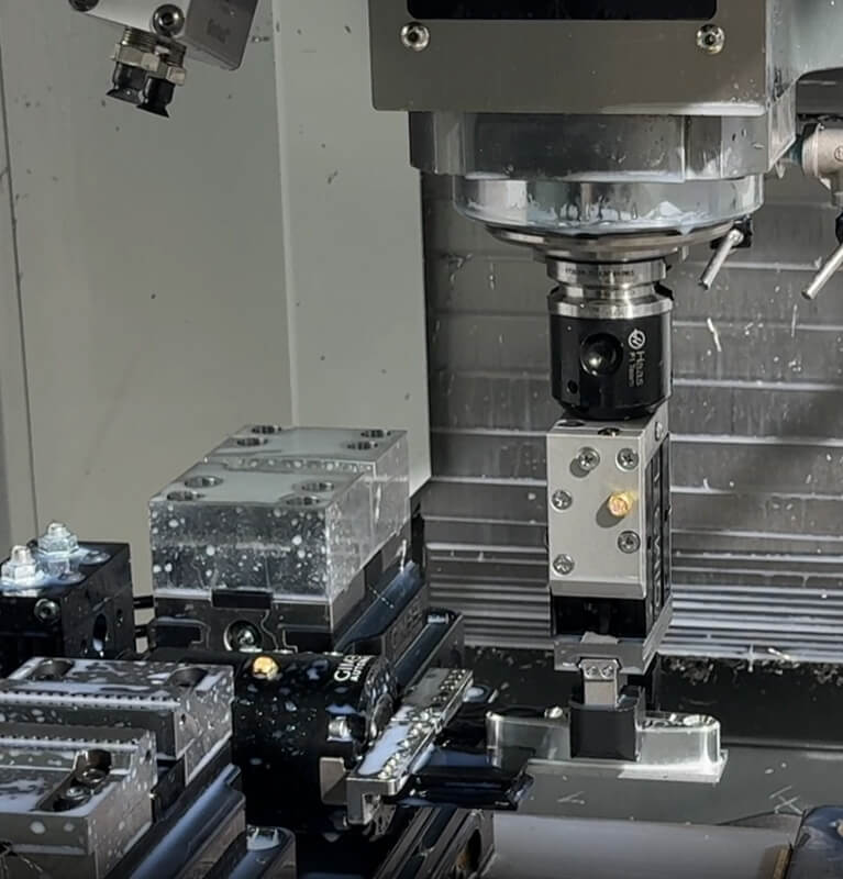 CNC spindle gripper loading a part into an AutoVise workholding system on a CNC mill